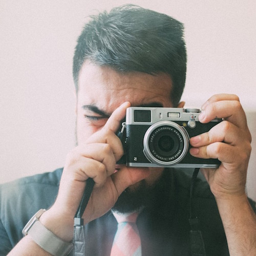 A lovely photograph of Ali Karbassi holding a camera.